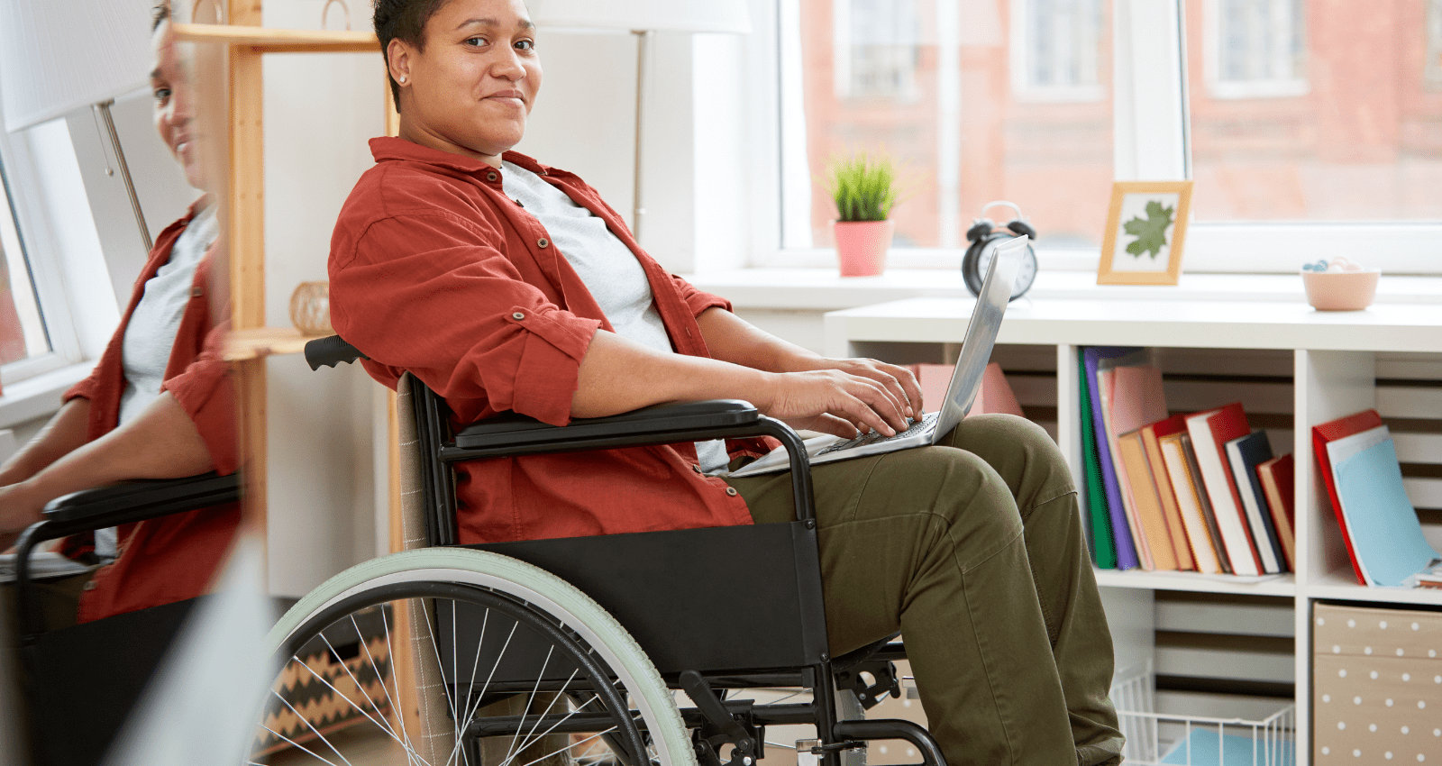 femme en fauteuil roulant sur son ordinateur portable chez elle